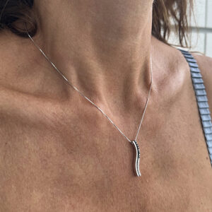 Foto gioiello indossata: collana in oro bianco con ciondolo pendente con diamanti bianchi e neri