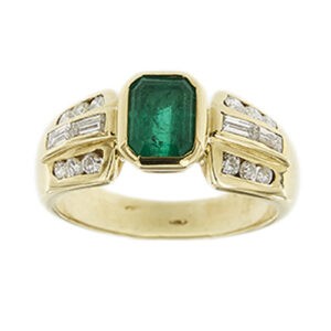 Anello a fascia in oro giallo 18kt con smeraldo rettangolare centrale da 1.20 ct e 16 diamanti: 4 taglio baguette da 0.05 ct cad e 12 taglio brillante di cui 4 da 0.04 ct cad e 8 da 0.02 ct cad, totale 0.52 ct, colore FG - purezza VS.