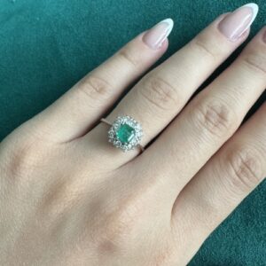 Foto gioiello indossata: anello in oro bianco halo con smeraldo centrale e diamanti