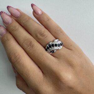 Foto gioiello indossata: anello a fascia in oro bianco con diamanti e zaffiri a onda