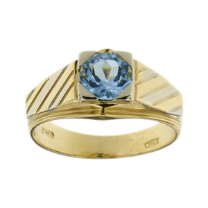 Anello chevalier in oro giallo 18 kt con topazio azzurro rotondo da 1,40 ct e ai lati righe nei due ori.