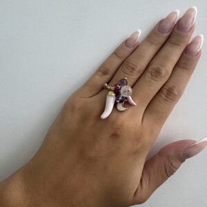 Foto gioiello indossata: anello in oro giallo con charms pendenti luna e cornetti smaltati e pietre rosa e viola