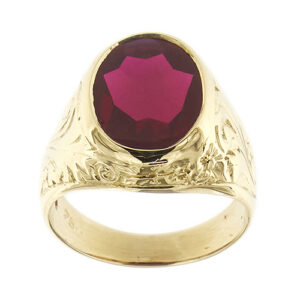 Anello uomo in oro giallo 18 kt con rubino sintetico ovale da 6 ct e gambo lavorato con motivi floreali.