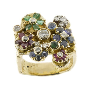 Anello a fascia in oro giallo 18 kt martellato lavorazione artigianale con gambo squadrato a tre fasce e fiori colorati impreziositi da 10 rubini, 9 zaffiri, 6 smeraldi, 12 diamanti taglio brillante: 1 da 0,020 ct, 2 da 0,07 ct ca, 1 da 0,05 ct, 3 da 0,04 ct cad, 5 da 0,02 ct cad e 3 diamanti taglio huit huit da 0,02 ct cad, totale 0,67 ct - colore GH, purezza SI.