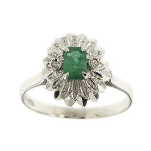 Anello in oro bianco 18 kt a fiore con petali a lavorazione diamantata, al centro uno smeraldo rettangolare da 0,40 ct e ai lati 2 diamanti taglio huit huit da 0,01 ct cad, totale 0,02 ct - colore FG, purezza VS.