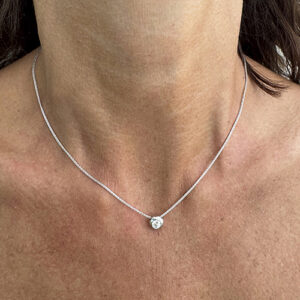 Foto gioiello indossata: collana in oro bianco punto luce con diamante a cipollino