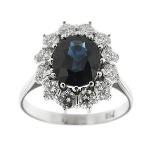 Anello halo in oro bianco 18kt con zaffiro a goccia da 2,50 ct e intorno 10 diamanti taglio brillante: 3 da 0,18 ct cad, 2 da 0,20 ct cad, 2 da 0,22 ct cad, 2 da 0,25 ct cad e 1 da 0,28 ct, totale 2,16 ct, colore FG, purezza VS