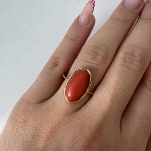 Foto gioiello indossata: anello in oro giallo con corallo cabochon